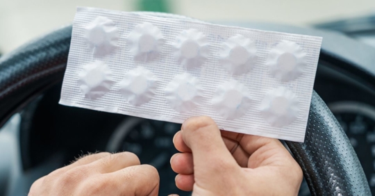Driver holding a pack of prescription medication